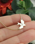 Gold necklace with a dove-shaped pendant on a hand against a blurred background - CG2028S,CG2030S,CG2032S