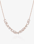 A rose gold personalized name necklace spelling out names with small heart-shaped accents and clear pavé stones, shown on a light gray background.