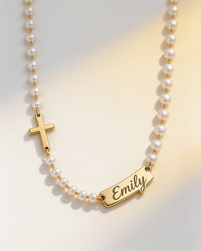 Personalized name cross pearl necklace in gold: sideways cross on one side, script name bar on the other