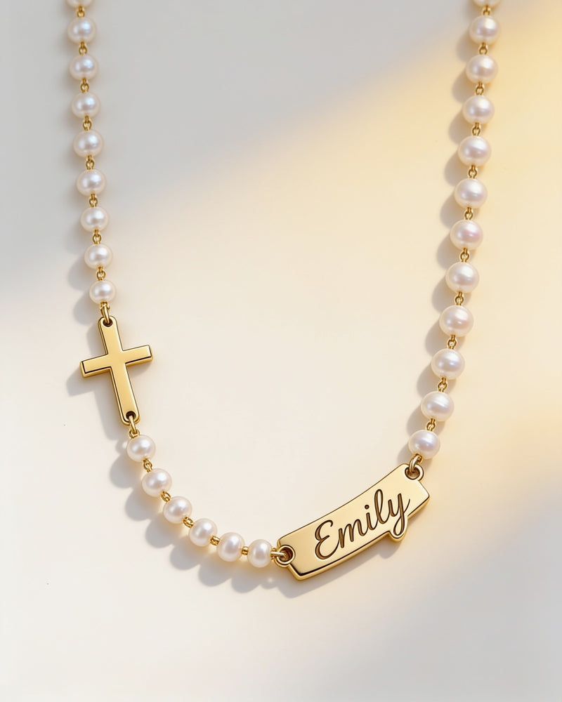 Personalized name cross pearl necklace in gold: sideways cross on one side, script name bar on the other
